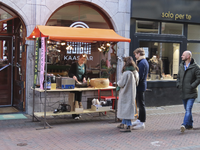 902271 Afbeelding van een kraampje voor Kaasbar Utrecht (Lijnmarkt 12) te Utrecht, waar een kaasrecept bereid ...